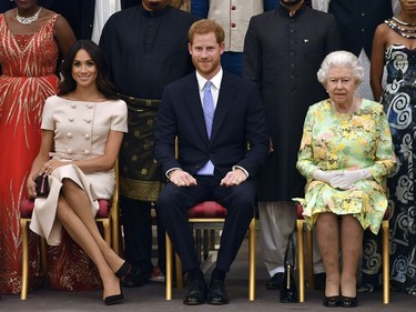 In this Tuesday, June 26, 2018 file photo, Queen Elizabeth, Prince Harry and Meghan, Duchess of Sussex pose for a group photo at the Queen's Young Leaders Awards Ceremony at Buckingham Palace in London.