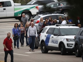 In this May 7, 2019 file photo, parents head into a recreation centre for students to get reunited with their parents after a shooting in Highlands Ranch, Colo.