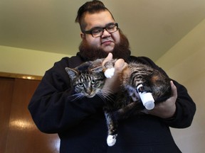 Adam Schofield holds his tabby cat named Sgt. Stubbs in his Oak Creek, Wis. apartment Friday, May 3, 2019.