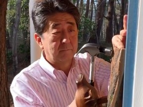 Prime Minister of Japan Shinzo Abe installs a beaver door knocker he brought back from Canada in this image taken from a video posted on his Instagram page.