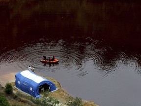 Members of the Cyprus Special Disaster Response Unit search for suitcases in a man-made lake, near the village of Mitsero outside of the capital Nicosia, Cyprus, Wednesday, May 1, 2019. Cyprus police spokesman Andreas Angelides says British experts called in to assist in the east Mediterranean island nation's serial killer case have been brought up to speed on the ongoing probe.