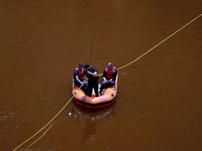 Members of the Cyprus Special Disaster Response Unit are seen in boat as they search for suitcases in a man-made lake, near the village of Mitsero outside of the capital Nicosia, Cyprus, Tuesday, April 30, 2019.