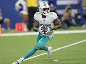 In this Nov. 25, 2018, file photo, Miami Dolphins cornerback Xavien Howard runs back an interception against the Indianapolis Colts during the first half of an NFL football game in Indianapolis. Howard has agreed to terms on a $76.5 million, five-year extension with the Dolphins, the most lucrative deal ever for an NFL cornerback. The contract includes $46 million guaranteed, and ensures Howard will be a cornerstone in the team's rebuilding effort under new coach Brian Flores.