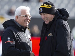 Hamilton Tiger-Cats head coach June Jones, right, laughs with B.C. Lions head coach Wally Buono during warm-up before CFL Football division semifinal game action in Hamilton, Ont. on Sunday, November 11, 2018.