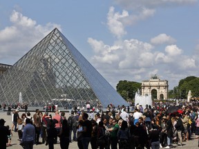 Tourists wait in line to visit the Louvre museum as it reopens, in Paris, Wednesday, May, 29, 2019.