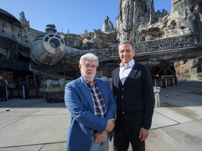 In this handout photo provided by Disneyland Resort, Walt Disney Company Chairman and CEO Bob Iger, right, and Star Wars creator George Lucas stand in front of the Millennium Falcon at Star Wars: Galaxy's Edge at Disneyland Park in Anaheim, Calif., May 29, 2019.  (Richard Harbaugh/ Disneyland Resort via Getty Images)