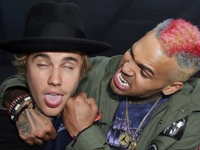 In this file photo taken on April 10, 2015,  Justin Bieber, left, and Chris Brown fool around at the Nylon Midnight Garden Party at a private residence in Bermuda Dunes, Calif.  (Chelsea Lauren/Getty Images for NYLON)