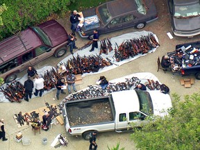 This photo from video provided by KCBS/KCAL-TV shows investigators from the U.S. Bureau of Alcohol, Tobacco, Firearms and Explosives and the police inspecting a large cache of weapons seized at a home in the affluent Holmby Hills area of Los Angeles Wednesday, May 8, 2019. Authorities seized more than a thousand guns from the home after getting an anonymous tip regarding illegal firearms sales in a posh area near the Playboy Mansion and served a search warrant around 4 a.m. Wednesday at the property on the border of the Bel Air and Holmby Hills neighborhoods.