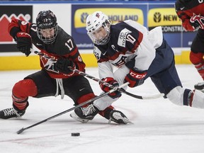 Team Canada's Bailey Bram (17) and Team USA's Meghan Duggan (10) battle for the puck during third period National Women's Team series hockey action in Edmonton, Alta., on Sunday December 17, 2017.
