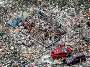Damaged vehicles sit amongst the debris of a deadly home explosion in Jeffersonville, Ind., on Sunday, May 19, 2019.