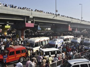 A crowd gathers to watch a building on fire in Surat, in the western Indian state of Gujarat, Friday, May 24, 2019.