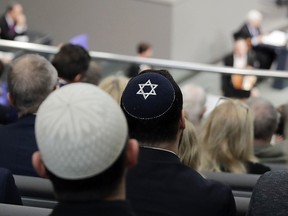 In this Thursday, Jan. 31, 2019, file photo, two men wearing skullcaps as they listen to the speech of Israeli Historian Saul Friedlaender, during a remembrance event of the parliament Bundestag at the Reichstag building in Berlin. (AP Photo/Markus Schreiber)