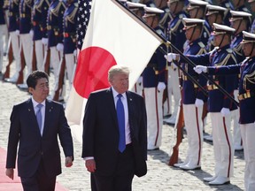 In this Nov. 6, 2017, file photo, U.S. President Donald Trump, second from left, reviews an honour guard during a welcome ceremony, escorted by Japanese Prime Minister Shinzo Abe at Akasaka Palace in Tokyo.