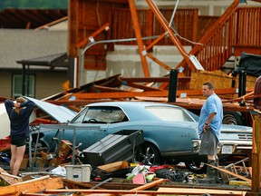 A man and woman inspect the damage to their home and classic cars after being hit by a tornado on Tuesday, May 28, 2019, in a neighbourhood south of Lawrence, Kan., near US-59 highway and N. 1000 Rd.