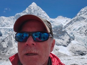 This April 2019 selfie photo provided by Mark Kulish shows his brother Christopher Kulish beneath Mount Everest.