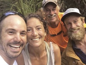 In this Friday, May 24, 2019, photo provided by Troy Jeffrey Helmer, resident Amanda Eller, second from left, poses for a photo after being found by searchers, Javier Cantellops, far left, Helmer and Chris Berquist above the Kailua reservoir in East Maui, Hawaii, on Friday afternoon.
