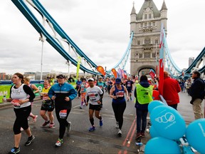 Competitors run across Tower Bridge as they compete in the 2019 London Marathon in central London on April 28, 2019. (TOLGA AKMEN/AFP/Getty Images)