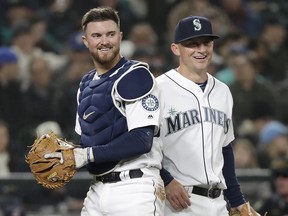 In this March 29, 2018, file photo, Seattle Mariners catcher Mike Marjama, left, and third baseman Kyle Seager smile after a play against the Cleveland Indians in Seattle. (AP Photo/Elaine Thompson, File)