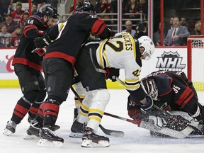 Boston Bruins forward David Backes tries to jam the puck past Carolina Hurricanes goalie Curtis McElhinney during Game 3 in Raleigh, N.C., on Tuesday. (Gerry Broome/The Associated Press)