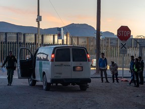 U.S. Border Patrol are pictured detaining and processing a group of migrants near the Paso Del Norte International Bridge connecting the U.S.-Mexico border cities of El Paso, Texas, and Ciudad Juárez, Chihuahua, Thursday night, April 18, 2019 in El Paso.
