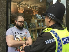 Paul Crowther speaks to police after Brexit Party leader Nigel Farage was hit with a milkshake during a campaign rally in Newcastle, England, Monday May 20, 2019.