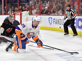 Brock Nelson of the New York Islanders dives to stop the puck after a save by Curtis McElhinney of the Carolina Hurricanes in the first period of Game 4 of the Eastern Conference Second Round during the 2019 NHL Stanley Cup Playoffs at PNC Arena on May 3, 2019 in Raleigh, N.C.