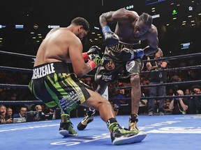 Deontay Wilder, right, knocks down Dominic Breazeale during the first round of the WBC heavyweight championship boxing match Saturday, May 18, 2019, in New York. Wilder stopped Breazeale in the first round.