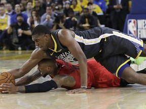 Golden State Warriors centre Kevon Looney, top, reaches for the ball over Portland Trail Blazers guard Damian Lillard during the second half of Game 2 of the NBA basketball playoffs Western Conference finals in Oakland, Calif., Thursday, May 16, 2019.
