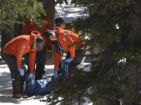 Members of an Alpine Rescue Team carry out the body of 18-year-old Sol Pais, near Echo Lake Campground in Arapaho National Forest, Wednesday, April 17, 2019, in Idaho Springs, Colo. (RJ Sangosti/The Denver Post via AP)