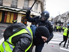 In this file photo taken on December 8, 2018 a riot police officer clashes with protestors near the Champs-Elysees in Paris during an anti-government demonstration. (ALAIN JOCARD/AFP/Getty Images)