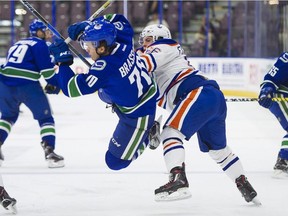 Edmonton Oilers' Trey Fix-Wolansky hits Vancouver Canucks' Matt Brassard. The Canucks aren't going to sign two defencemen, including Brassard, who were late choices in the 2017 NHL Entry Draft.
