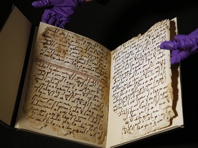 A university assistant shows fragments of an old Quran at the University in Birmingham Wednesday, July 22, 2015. (AP Photo/Frank Augstein)