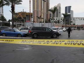 Sunny Isles Beach police officers stand near a van where an individual was found shot to death after a shooting on May 12, 2019 in Sunny Isles, Fla.