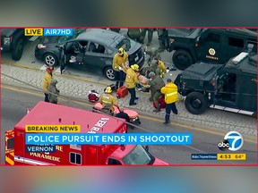 In this photo taken from video provided by KABC-TV, medics and officers tend to a wounded man after he was removed from his shot-up car, top left, at the conclusion of a wild car chase and rolling shootout in the Los Angeles area Friday afternoon, May 10, 2019.