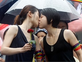 Same-sex marriage supporters kiss outside the Legislative Yuan Friday, May 17, 2019, in Taipei, Taiwan after the legislature passed a law allowing same-sex marriage in a first for Asia.