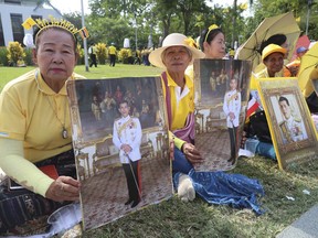 Thai well-wishers hold the portraits of Thailand's King Maha Vajiralongkorn outside the Grand Palace in Bangkok, Thailand, Monday, May 6, 2019.