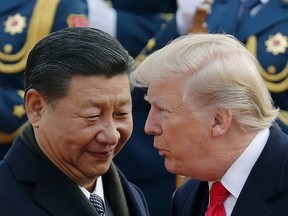 In this Nov. 9, 2017, file photo, U.S. President Donald Trump, right, chats with Chinese President Xi Jinping during a welcome ceremony at the Great Hall of the People in Beijing.