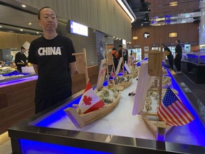 A shopper eyes display of seafood including oysters from the U.S. at a supermarket in Beijing on Tuesday, May 14, 2019.