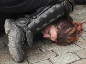 Police detain a woman during a yellow vest protest with other groups in Brussels, Sunday, May 26, 2019. (AP Photo/Francisco Seco)