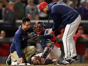 Trainer Masa Abe and manager Rocco Baldelli #5 of the Minnesota Twins check on Mitch Garver #18 after a collision at home plate with Shohei Ohtani #17 of the Los Angeles Angels of Anaheim during the eighth inning of the game on May 14, 2019 at Target Field in Minneapolis, Minnesota.