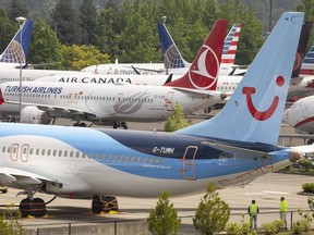 Workers stand near Boeing 737 MAX airplanes as they sit parked at a Boeing facility adjacent to King County International Airport, known as Boeing Field, on May 31, 2019 in Seattle, Washington.
