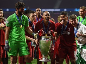 Alisson, Fabinho, Roberto Firmino and Alberto Moreno of Liverpool celebrate with the Champions League Trophy after winning the UEFA Champions League Final between Tottenham Hotspur and Liverpool at Estadio Wanda Metropolitano on June 1, 2019 in Madrid, Spain. (Matthias Hangst/Getty Images)
