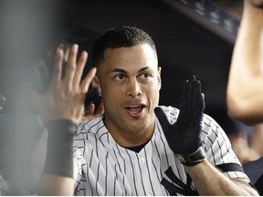 Giancarlo Stanton of the New York Yankees celebrates with teammates in the dugout after hitting a home run against the Toronto Blue Jays at Yankee Stadium on June 24, 2019 in New York City.