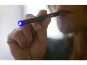 This September 25, 2013 file photo illustration  shows a woman smoking an "Blu" e-cigarette (electronic cigarette) in Washington,DC.
