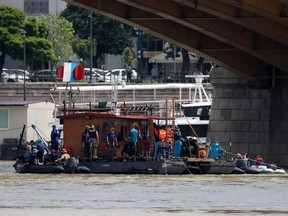 Divers prepare themselves on a boat at the position of the sunk Hungarian riverboat as the search for the missing boat passengers continue on June 6, 2019 following a boat accident on the Danube river in Budapest. - The bodies of two more South Korean tourists have been found after a sightseeing vessel sunk in Budapest last week, bringing the death toll to 15, with 13 still missing, police said. The Mermaid with mainly South Koreans aboard overturned and sank May 29, seconds after colliding with a bigger cruise ship on a busy stretch of the Danube river in the heart of Budapest.
