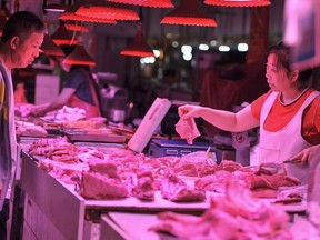A customer buys meat at a market in Shenyang in China's northeastern Liaoning province on June 12, 2019.
