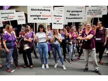Women whistle and hold placards during in a nation-wide women's strike for wage parity, on June 14, 2019 in Swiss capital Bern.
