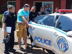 This handout from the Crime Suppression Division of the Royal Thai Police taken on June 15, 2019 and released on June 16, 2019 shows Italian national Francesco Galdelli (C) after he was arrested on the outskirts of Pattaya. - An Italian who masqueraded as Hollywood superstar George Clooney to sell clothes online has been arrested with his wife in Thailand after years on the run, police said on June 16.