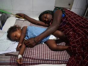 In this picture taken on June 20, 2019, an Indian mother lays next to her child who is suffering from Acute Encephalitis Syndrome (AES), at Kejriwal  hospital in Muzaffarpur in the Indian state of Bihar. - From lychees to heat, the factors behind almost 120 children dying in eastern India this month are many. But there are two underlying and preventable root causes: poverty and bad governance. In Bihar state's Hichara, for instance, where the outbreak still rages, there are no toilets, no running water and no cooking gas for the group of thatched huts that make up the village.