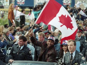 Toronto Blue Jays' Joe Carter waves the Canadian flag alongside his wife Diana during a World Series victory parade in Toronto on Sunday, October 24, 1993. The Raptors' historic NBA championship win last week marked the first time a Canadian team has won one of the big four professional sports championships since the Toronto Blue Jays won the 1993 World Series.